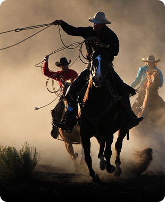 A group of men riding horses in the dust.