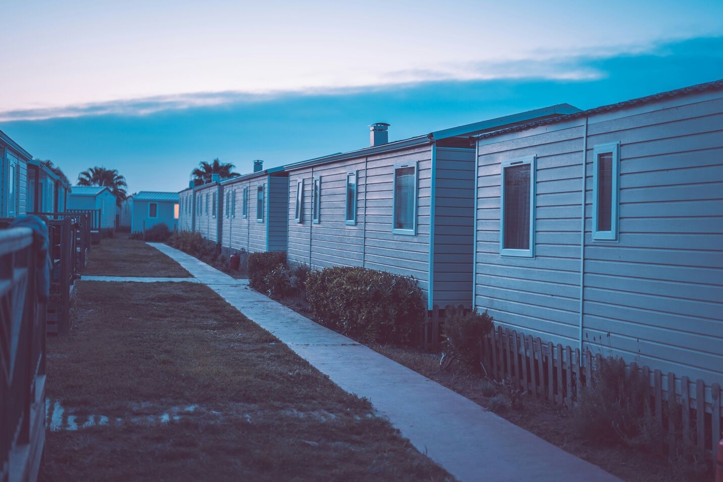 A row of mobile homes on the side of a road.