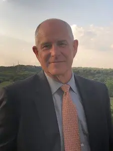 A man in a suit and tie standing outside.